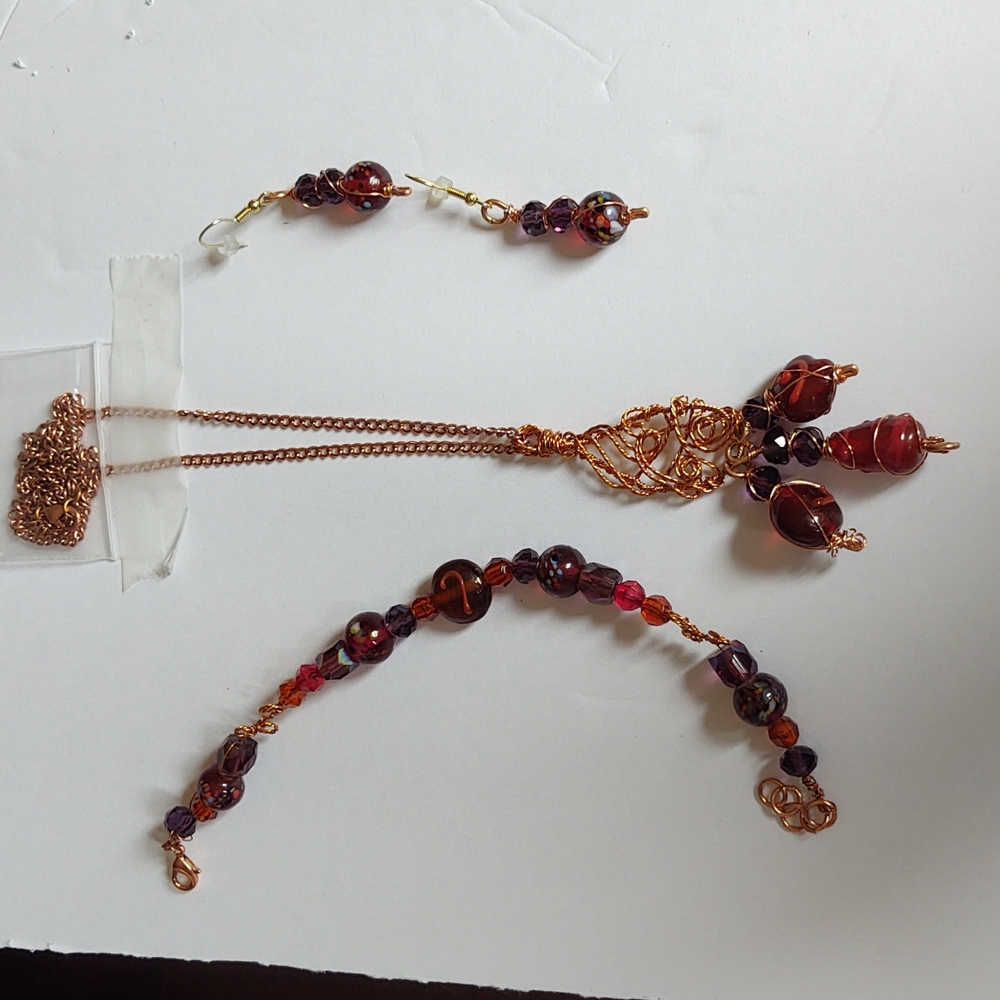 The necklace is glass beads and they are done with a gold filigree wire
